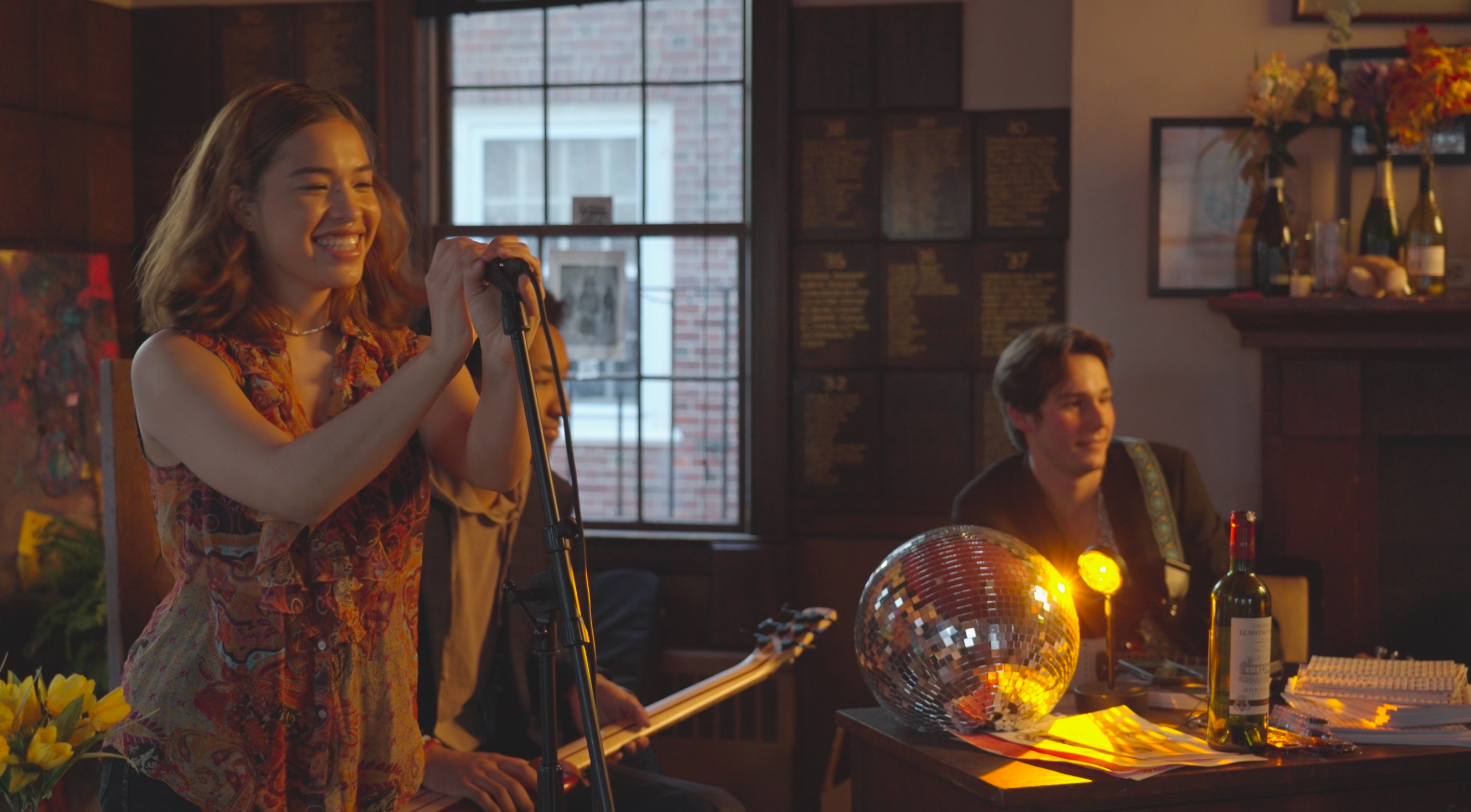 The Harvard Advocate sanctum, with a musician playing to a small crowd.